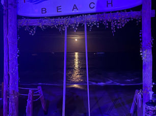 Full moon over the ocean behind the Tamara Beach Club swing in Los Cabos