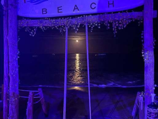 Full moon over the ocean behind the Tamara Beach Club swing in Los Cabos